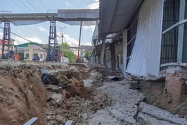 Nhà kho của Công ty Lương thực Hưng Phước bị sụt lún sâu so với mặt đường tỉnh 921. (Ảnh: Thanh Liêm/TTXVN)