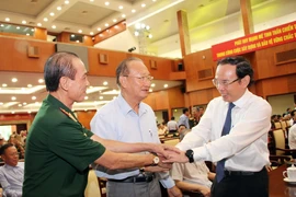 Ông Nguyễn Văn Nên, Ủy viên Bộ Chính trị, Bí thư Thành ủy Thành phố Hồ Chí Minh, thăm hỏi sức khỏe các cựu chiến binh tham dự buổi họp mặt. (Ảnh: Xuân Khu/TTXVN)