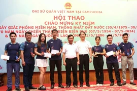 Đại sứ Việt Nam tại Campuchia Nguyễn Huy Tăng (giữa) trao giải Nhất, Nhì, Ba cho các vận động viên thi đấu môn cầu lông. (Ảnh: Hoàng Minh/TTXVN)