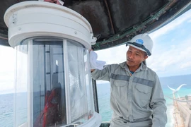 Công nhân Công ty đảm bảo an toàn hàng hải Biển Đông và Hải đảo (Tổng Công ty bảo đảm an toàn hàng hải miền Nam) Nguyễn Minh Thắng bảo dưỡng đèn hải đăng trên đảo An Bang. (Ảnh: Hoàng Hiếu/TTXVN)