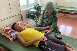 Quân y Đồn Biên phòng Cửa khẩu Cảng Gianh thăm khám sức khỏe cho ngư dân Nguyễn Văn Quang. (Ảnh: TTXVN phát)