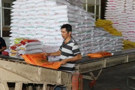 Đóng gói gạo tại cơ sở lau bóng gạo Giàu Thanh Hoàng ở chợ gạo Bà Đắc-An Cư (Cái Bè, Tiền Giang). (Ảnh: Hữu Chí/TTXVN)