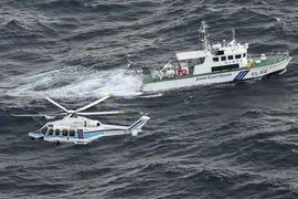 Tàu và trực thăng của Lực lượng Bảo vệ bờ biển Nhật Bản làm nhiệm vụ ở ngoài khơi đảo Yakushima. (Ảnh: Kyodo/TTXVN)