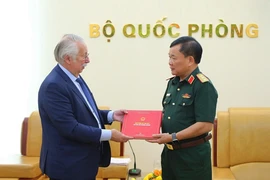 Thượng tướng Hoàng Xuân Chiến (phải) trao tặng ngài André Flahaut Sách trắng Quốc phòng Việt Nam 2019. (Ảnh: Hồng Pha/TTXVN phát)