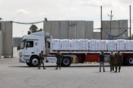 Lực lượng an ninh Israel kiểm tra xe chở hàng nhân đạo vào Dải Gaza qua cửa khẩu Kerem Shalom. (Ảnh: AFP/TTXVN)