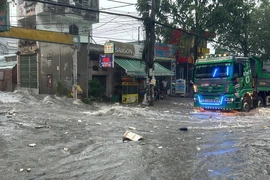 Nước ngập chảy xiết tại khu vực ngã ba Trảng Dài, thành phố Biên Hòa, Đồng Nai khiến người dân di chuyển khó khăn. (Ảnh: Lê Xuân/TTXVN)