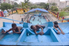 Trẻ em vui chơi tránh nóng tại hồ bơi ở Karachi, Pakistan. (Ảnh: THX/TTXVN)
