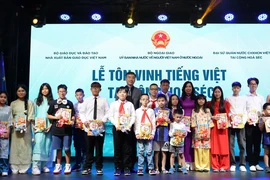 Thứ trưởng Bộ Ngoại giao Lê Thị Thu Hằng, Đại sứ Dương Hoài Nam, Tổng Biên tập Nhà Xuất bản Giáo dục Việt Nam Phạm Vĩnh Thái trao tặng sách cho các học sinh người Việt tại Séc. (Ảnh: Việt Dũng/TTXVN)