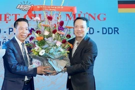 Ông Phạm Huy Phương, Bí thư thứ nhất, Thường trực ban Công tác Cộng đồng Đại sứ quán Việt Nam tặng hoa cựu cán bộ, phiên dịch và đội trưởng hợp tác lao động Việt Nam và CHDC Đức. (Ảnh: Phương Hoa/Vietnam)