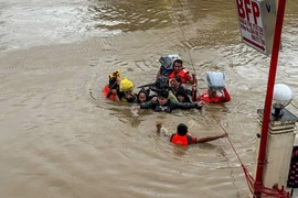 Lực lượng cứu hộ sơ tán người dân khỏi vùng ngập lụt do bão Trami tại tỉnh Camarines Sur, Philippines. (Ảnh: THX/TTXVN)