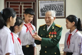 Học sinh Trường THCS Thượng Lan, huyện Việt Yên đến thăm hỏi và nghe Anh hùng Chu Văn Mùi kể chuyện. (Ảnh: Danh Lam/TTXVN)