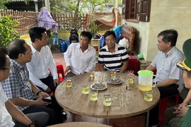 Lãnh đạo tỉnh Quảng Bình thăm hỏi các ngư dân được cứu sống trở về địa phương. (Ảnh: TTXVN phát)