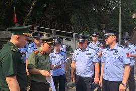 Lực lượng chức năng hai nước tiến hành các thủ tục trao trả 4 người Trung Quốc nhập cảnh trái phép vào Việt Nam. (Ảnh: TTXVN phát)