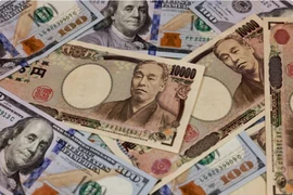 Đồng tiền mệnh giá 10.000 yen và 100 USD. (Ảnh minh họa: AFP/TTXVN)