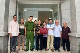 Công an xã Quảng Phú Cầu trao trả tài sản cho bà Ngọt và gia đình. (Ảnh: TTXVN phát)