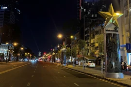 Nhiều bảng quảng cáo trang trí và các khu vực công cộng trên đường Lê Lai (Quận 1) đã tắt hoặc giảm 50% công suất hệ thống chiếu sáng. (Ảnh: Thanh Vũ/TTXVN)