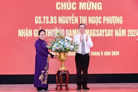 Ông Nguyễn Phước Lộc, Phó Bí thư Thành ủy, Chủ tịch Ủy ban Mặt trận Tổ quốc Việt Nam Thành phố Hồ Chí Minh tặng hoa chúc mừng Giáo sư Nguyễn Thị Ngọc Phượng. (Ảnh: Đinh Hằng/TTXVN)