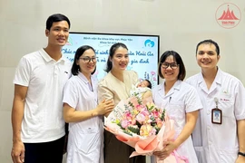 Bé H.A xuất viện trong niềm vui của gia đình và đội ngũ y, bác sỹ Bệnh viện Đa khoa khu vực Phúc Yên. (Ảnh: TTXVN phát)