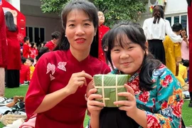Học sinh Trường Trung học Cơ sở - Trung học Phổ thông Newton cơ sở 1 tự tay gói bánh dành tặng các bạn nhỏ Làng trẻ Hòa Bình. (Ảnh: PV/Vietnam+)