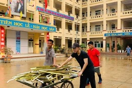 Giáo viên dọn dẹp trường sau bão Yagi. (Ảnh: PV/Vietnam+)