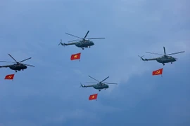 Trực thăng mang cờ Tổ quốc diễu qua lễ đài (Ảnh: TTXVN)