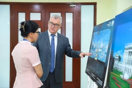 Các đại biểu xem triển lãm ảnh về Liên bang Nga tại Liên hiệp các tổ chức hữu nghị Việt Nam ngày 15/5. (Ảnh: CTV/Vietnam+)