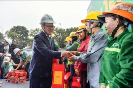 Tổng Biên tập Báo Nhân Dân Lê Quốc Minh trao quà cho các công nhân xây dựng tại công trường Ecopark, Hưng Yên năm 2024. (Ảnh: CTV/Vietnam+) 