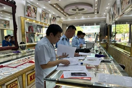 Quản lý Thị trường Quảng Ninh phối hợp với Ngân hàng Nhà nước kiểm tra hoạt động kinh doanh vàng tại Móng Cái. (Ảnh: PV/Vietnam+)