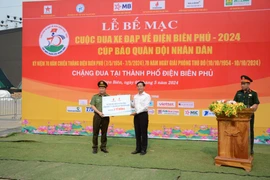 Đại diện Petrovietnam trao hỗ trợ kinh phí; chụp ảnh lưu niệm tại vòng đua cuối cùng nhân kỷ niệm 70 năm chiến thắng Điện Biên Phủ. (Ảnh: PV/Vietnam+) 