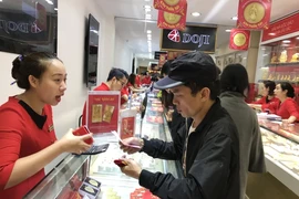 Khách hàng giao dịch vàng tại Hà Nội. (Ảnh: PV/Vietnam+)