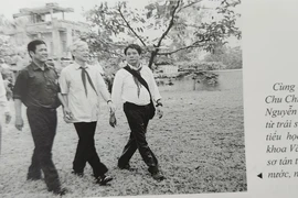 Nhà báo, Nghệ sỹ nhiếp ảnh Chu Chí Thành (bên trái cầm máy ảnh) và đồng chí Nguyễn Phú Trọng thăm trường tiểu học xã Vạn Thọ, năm 2005 - nơi khoa Văn, Đại học Tổng hợp Hà Nội sơ tán thời chống Mỹ cứu nước. (Ảnh tác giả cung cấp)