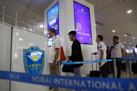Hành khách xếp hàng vào làm thủ tục an ninh tại nhà ga T1 Sân bay Nội Bài. (Ảnh: Huy Hùng/TTXVN)