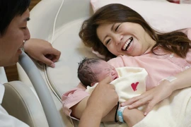 Niềm vui của một cặp vợ chồng vừa sinh con tại tại bệnh viện ở Kawagoe, Nhật Bản. (Ảnh: AFP/TTXVN)
