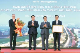 Chủ tịch Quốc hội Vương Đình Huệ chúc mừng lãnh đạo tỉnh Phú Yên nhận Quyết định của Thủ tướng Chính phủ phê duyệt quy hoạch tỉnh Phú Yên thời kỳ 2021-2030, tầm nhìn đến năm 2050. (Ảnh: Nhan Sáng/TTXVN)