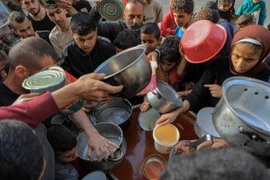 Người dân chờ nhận lương thực viện trợ ở thành phố Rafah, phía Nam Dải Gaza ngày 30/3/2024. (Ảnh: THX/TTXVN)