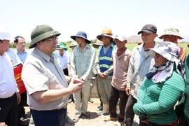 Thủ tướng Phạm Minh Chính trao đổi với người lao động thi công hệ thống thủy lợi Tân Mỹ, đoạn qua huyện Ninh Sơn. (Ảnh: Dương Giang/TTXVN)