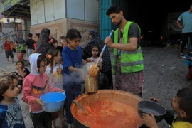 Các em nhỏ nhận thực phẩm cứu trợ tại thành phố Rafah, Dải Gaza, ngày 28/4/2024. (Ảnh: THX/TTXVN)