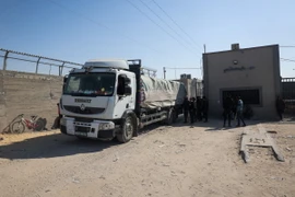 Xe tải chở hàng viện trợ qua cửa khẩu Kerem Shalom vào Dải Gaza ngày 15/4/2024. (Ảnh: AFP/TTXVN)