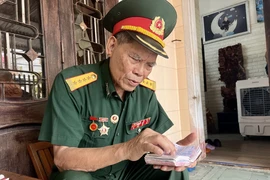 Đại tá Lê Kim Thơ (Cục Tham mưu Công binh, Bộ Tư lệnh Đoàn 559) lưu giữ cẩn thận cuốn sổ ghi chép ghi lại thời hoa lửa chiến đấu trên tuyến đường Trường Sơn huyền thoại. (Ảnh: Nguyên Linh/TTXVN)
