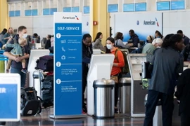 Hành khách làm thủ tục tại sân bay ở Arlington, Virginia, Mỹ. (Ảnh: AFP/TTXVN)