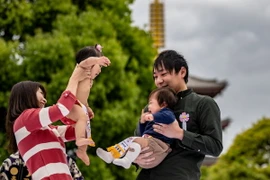 Một cặp vợ chồng cùng hai con tham dự một sự kiện tại đền Sensoji ở Tokyo, Nhật Bản. (Ảnh: AFP/TTXVN)