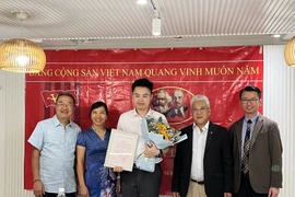 Đinh Vũ Tùng Lâm chụp ảnh cùng các bí thư chi bộ Việt Nam tại Hong Kong. (Ảnh: Mạc Luyện/Vietnam+)