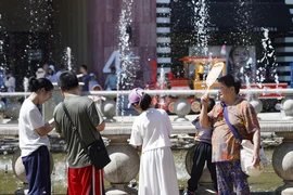 Người dân tránh nóng bên đài phun nước tại Bắc Kinh, Trung Quốc. (Ảnh: THX/TTXVN)