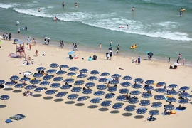Người dân tránh nóng trên bãi biển ở Busan, Hàn Quốc, ngày 19/6/2024. (Ảnh: Yonhap/TTXVN)