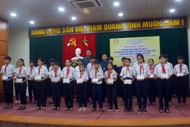 Đại diện Hiệp hội Doanh nghiệp Hàn Quốc tại Quảng Nam và Hội Khuyến học thành phố Tam Kỳ trao học bổng cho học sinh vượt khó học giỏi. (Ảnh: Trịnh Bang Nhiệm/TTXVN)