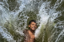 Trẻ em làm mát trong ngày nắng nóng gay gắt ở Dhaka, Bangladesh, ngày 29/4/2024. (Ảnh: AFP/TTXVN)