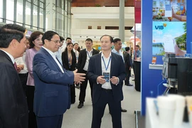 Thủ tướng Phạm Minh Chính, Thống đốc Nguyễn Thị Hồng cùng đại diện các cơ quan nhà nước tham quan gian hàng của VIB tại Sự kiện Chuyển đổi số ngành Ngân hàng năm 2024. (Ảnh: Vietnam+)