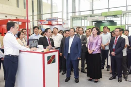 Thủ tướng Chính phủ Phạm Minh Chính, Thống đốc NHNN Nguyễn Thị Hồng đến thăm gian hàng của Agribank tại sự kiện. (Ảnh: Vietnam+)