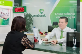 Giao dịch viên Lê Xuân Tiến tại phòng giao dịch Như Quỳnh Vietcombank Hưng Yên. (Ảnh: Vietnam+)