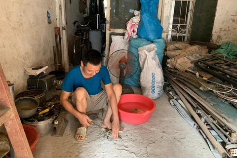 Những người lao động tại Thủ đô phải tìm những cách 'đối phó' như đổ nước đá vào chậu nước rồi bật quạt để tránh nóng. (Ảnh: Ngọc Anh/Vietnam+)